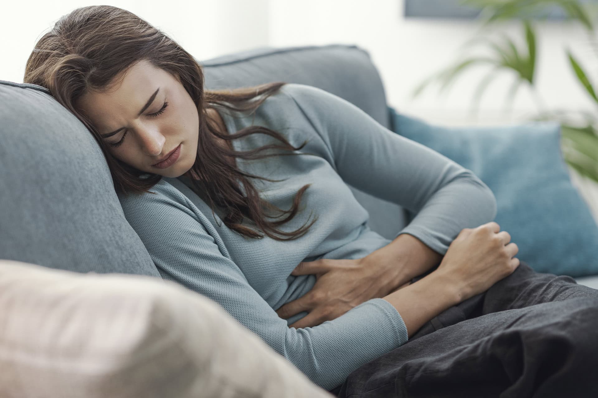 donna con dolore alla pancia sul divano